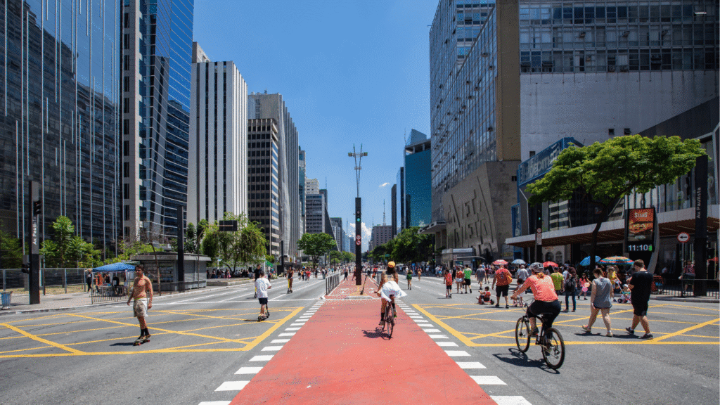 Vista da Avenida Paulista com seus prédios icônicos e movimento de pessoas, representando o cenário das gírias paulistanas.