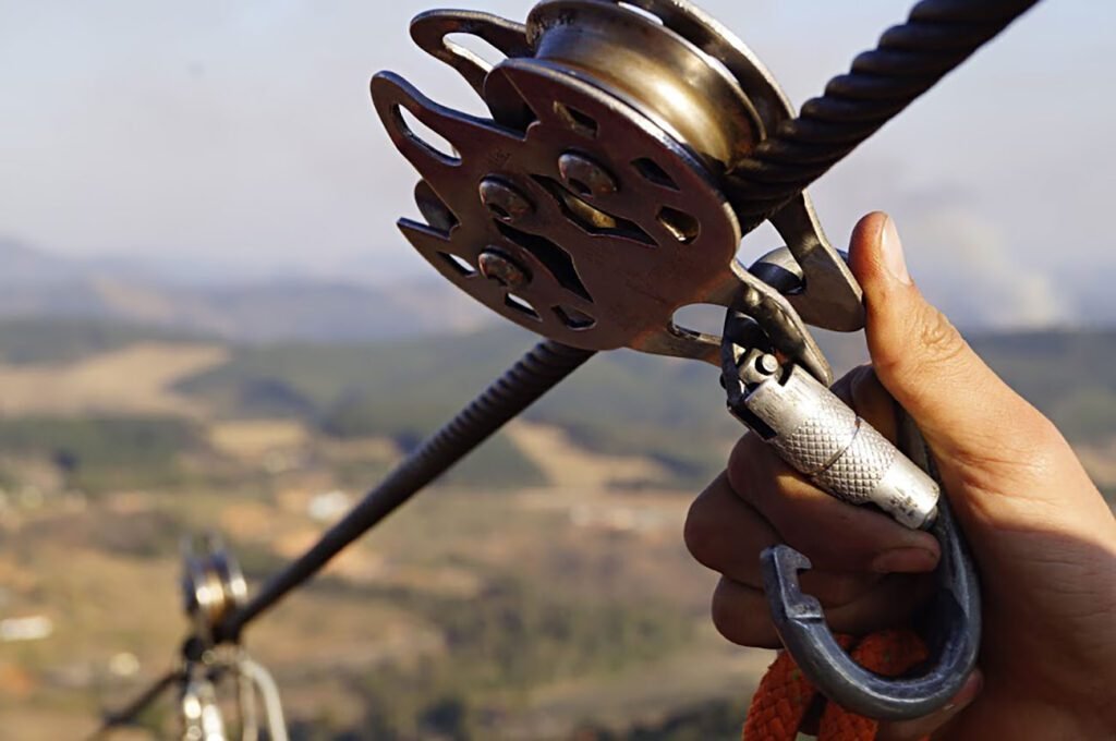 Visitante descendo pela maior tirolesa das Américas em Pedra Bela, São Paulo, com vistas deslumbrantes da natureza ao redor.