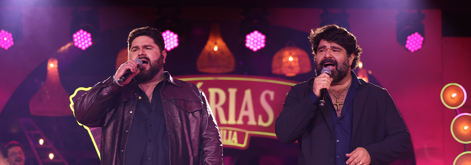 César Menotti e Fabiano se apresentando ao vivo em um show no Espaço Unimed em São Paulo, com público emocionado ao fundo.