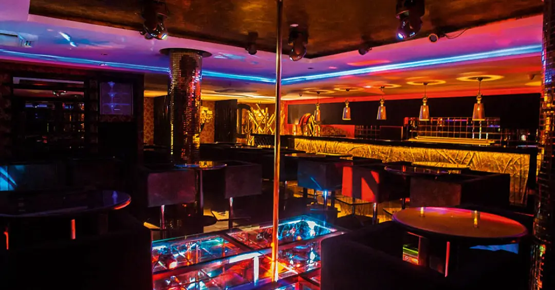 Vista panorâmica de uma balada liberal luxuosa em São Paulo com iluminação neon.