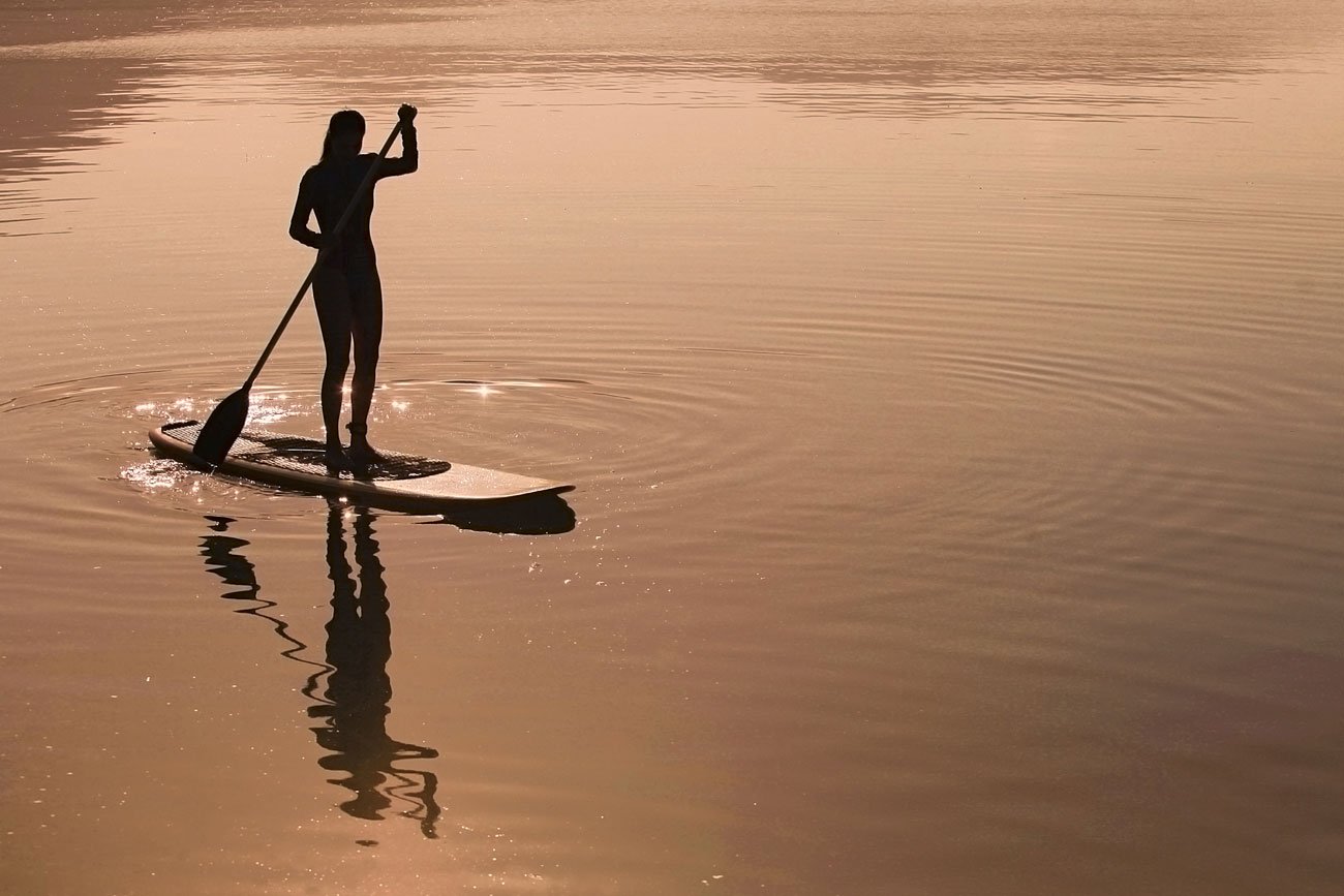 Praticante de stand up paddle na represa Guarapiranga em São Paulo