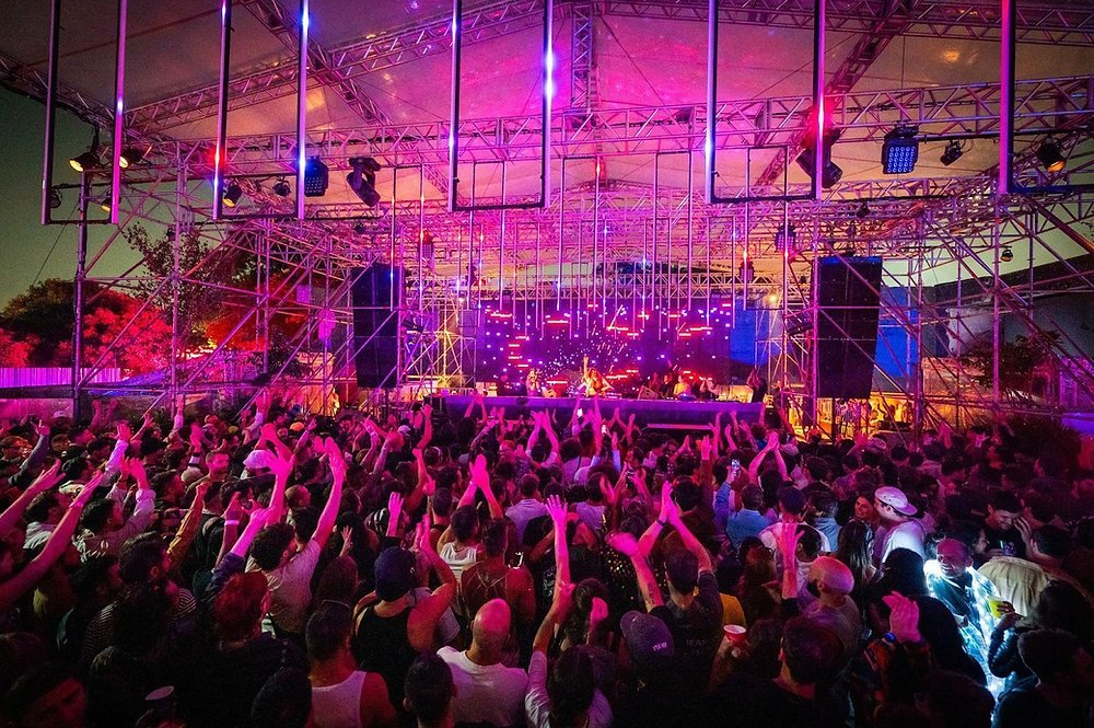 Público se divertindo no Gop Tun Festival 2026 em São Paulo, com cores vibrantes e luzes de festa.