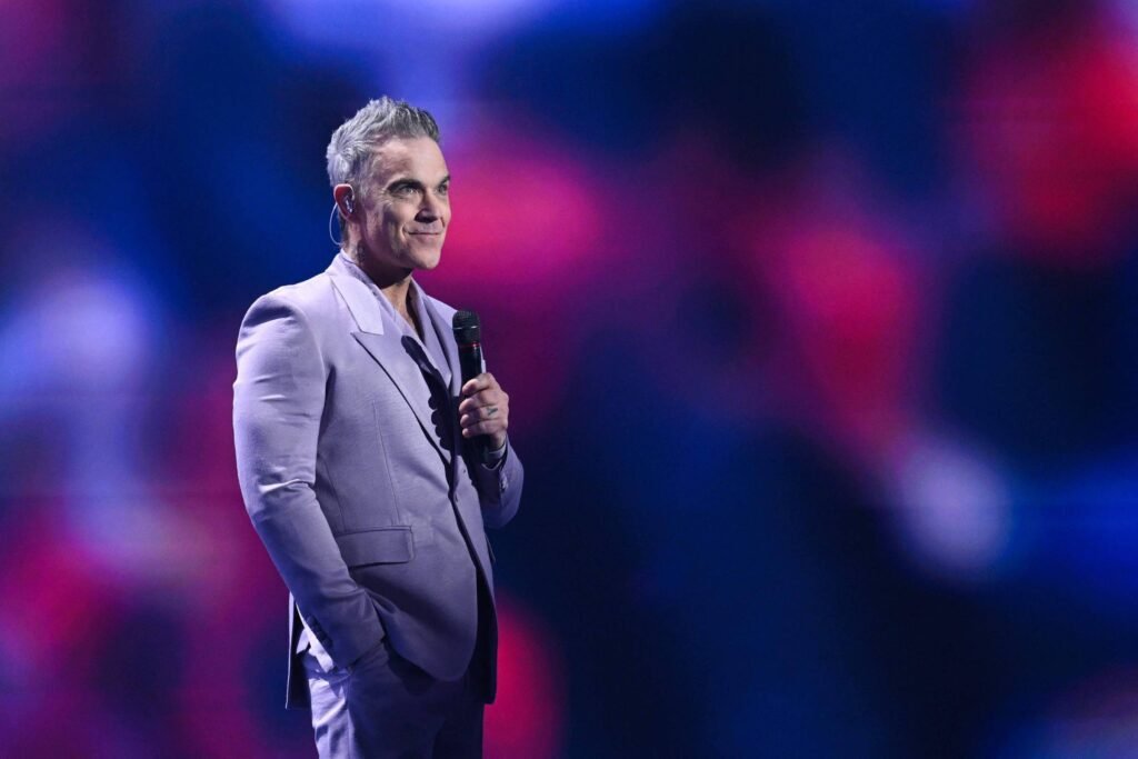 Robbie Williams em show ao vivo no Brasil, com público animado