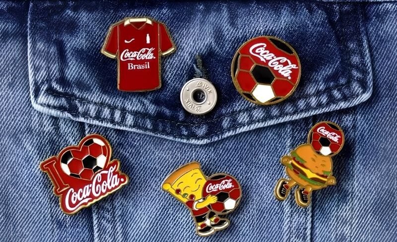 Coleção de pins colecionáveis da Coca-Cola com temática de futebol, pizza e hambúrguer