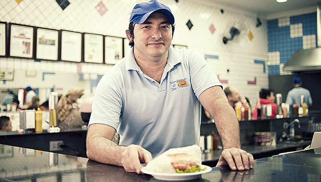 Hambúrguer artesanal do Seu Oswaldo com pão fresquinho, molho de tomate caseiro e maionese artesanal.