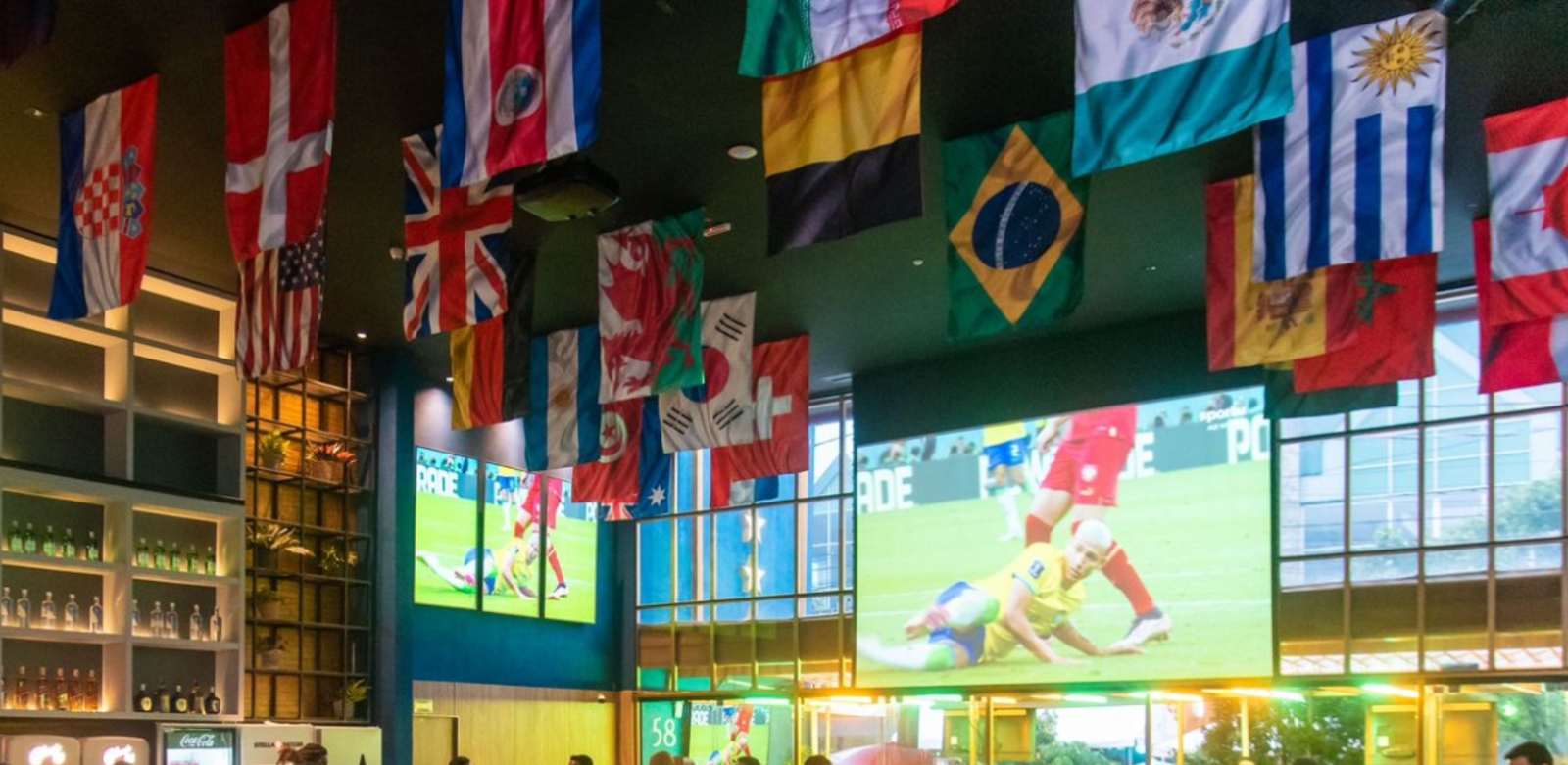 Torcedores animados assistindo a uma partida de futebol em um bar durante a Copa do Mundo