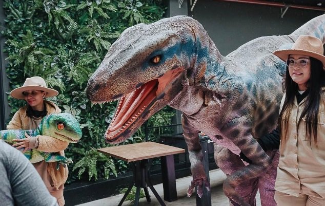 Crianças interagindo com dinossauros no Canto dos Dinossauros em Osasco