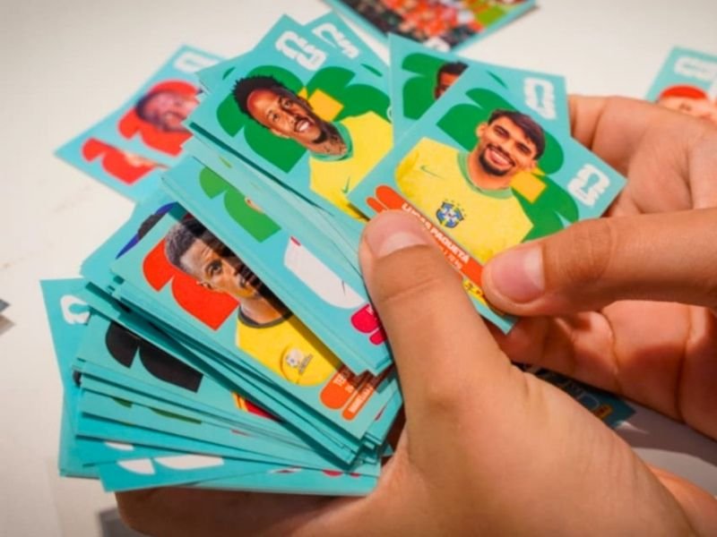 Crianças felizes segurando álbuns e figurinhas da Copa do Mundo