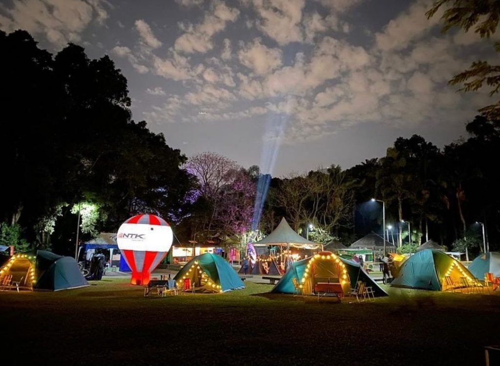 Famílias acampando sob um céu estrelado durante o evento Meu Teto de Estrelas no Camping das Pedras.