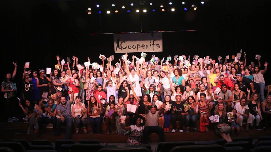 Participantes do Sarau da Cooperifa recitando poesias em um ambiente acolhedor e cultural
