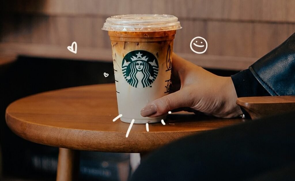 Copo de Caramelo Macchiato da Starbucks em um ambiente aconchegante da cafeteria
