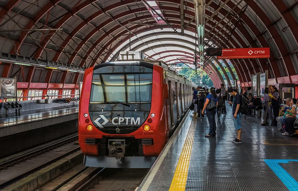Estação Itaquaquecetuba com passageiros interagindo com a Bancada Literária e escolhendo livros
