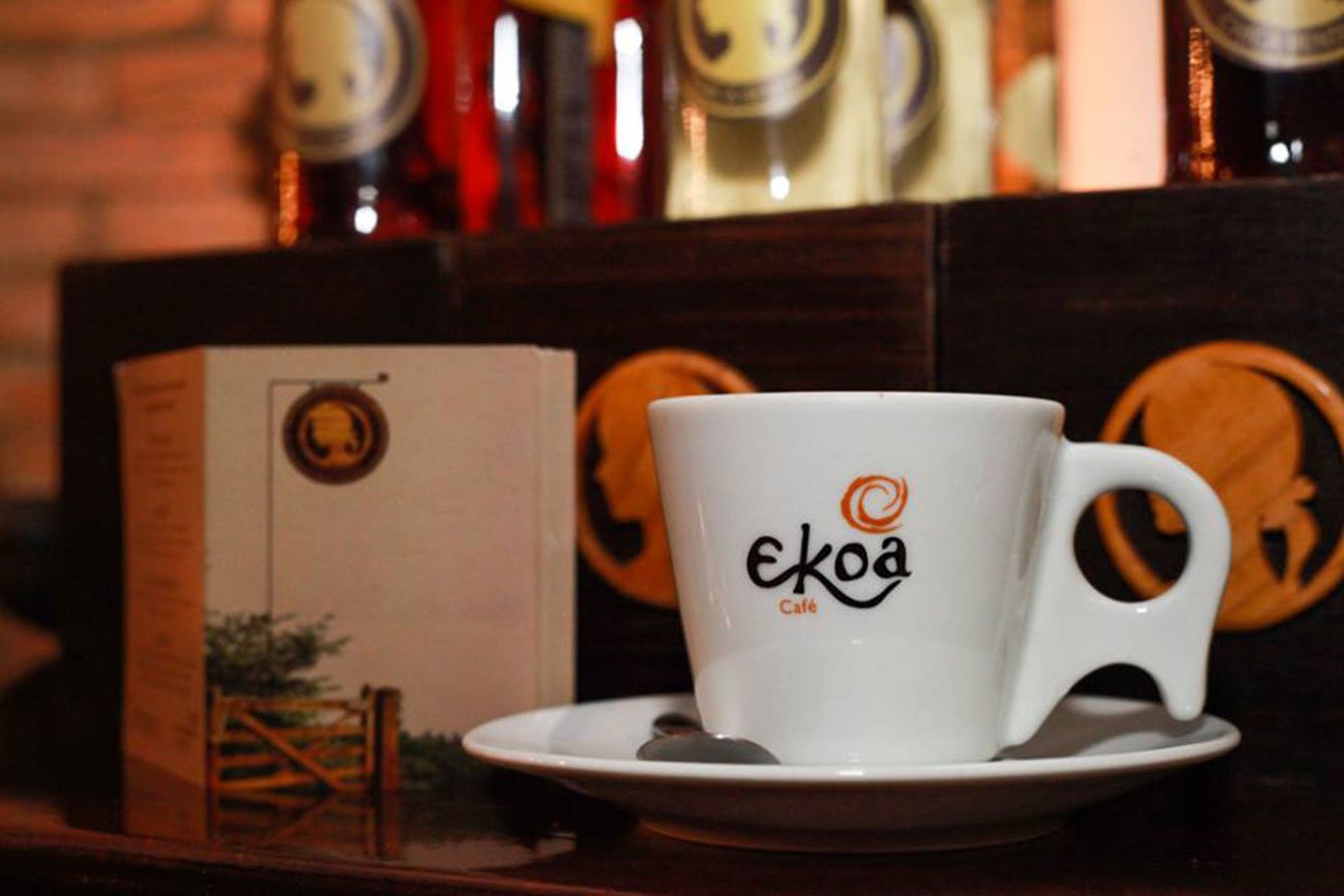 Café Ekoa na Vila Madalena, São Paulo, com pessoas desfrutando de uma experiência de café compartilhado.
