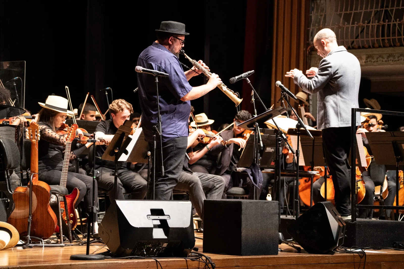 Músicos da Orquestra Jovem Tom Jobim se apresentando em concerto.